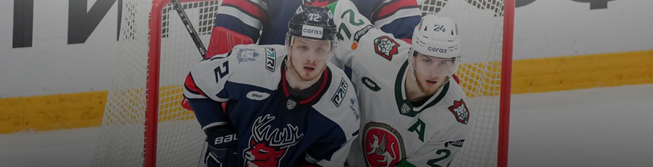 Хоккейный матч: два игрока возле защитной сетки, один в темной форме с номером 22, второй в светлой форме с номером 26. Они находятся на льду, позади видна часть другой команды